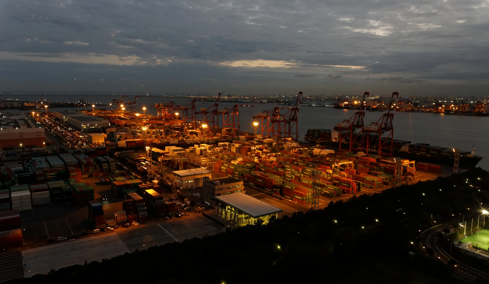 Gantry cranes and shipping containers at a container terminal at blue hour